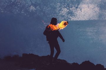 Man carrying burning torch at night.